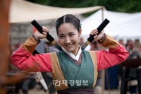 韓国MBC週末ドラマ『Dr.JIN』でヨンレ役を演じるパク・ミニョンが両手に剣を持ち、キュートな笑顔を浮かべて武術を披露している。写真=イギムプロダクション