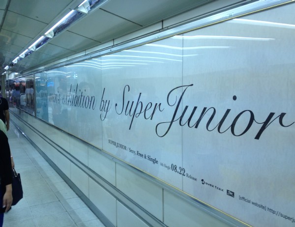 SUPER JUNIORの巨大バナー「sexy men's exhibition」が24日、渋谷駅で公開された。（2012年8月24日渋谷駅付近にて）