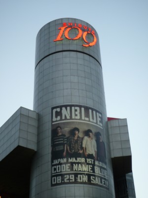 ファッションビル「渋谷109」にCNBLUEが明日29日のリリースを控えたメジャー1stアルバム「CODE NAME BLUE」の巨大ビジュアルボードが掲示されている。（2012年8月24日、東京都渋谷区）